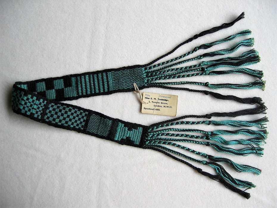 Colour photograph of a weaving sample in black and green.